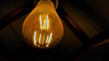 Karanlık sahnede titreyen yaşlı Edison Ampulü