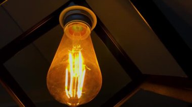 Karanlık sahnede titreyen yaşlı Edison Ampulü