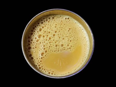 Dispossible Cup 'taki sütlü çay siyah arkaplanda izole edildi