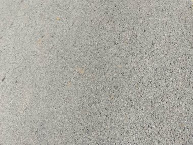 Gömülü Çakıl Taşları ve Renk Değiştirme Desenleriyle Sert Gri Beton Yüzey