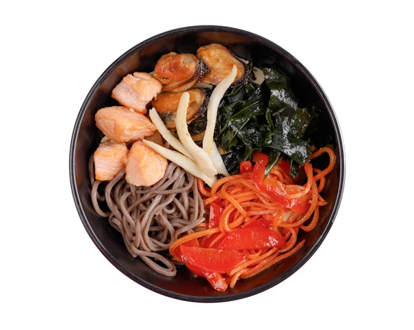 Somon, midye, mürekkep balığı, karabuğday lokshina, havuç, dolma biber, wakame yosunu, yeşil cibula, beyaz arkaplanda online restoran menüsü için beyaz susam.