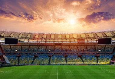 Spor stadyumundaki futbol sahasında. Çevredeki ışıkların aydınlattığı çimenler. .