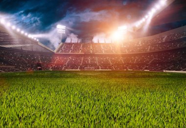 Spor stadyumundaki futbol sahasında. Çevredeki ışıkların aydınlattığı çimenler. .
