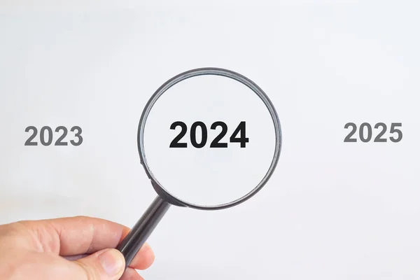 year 2024 in a magnifying glass.past and future years.new year idea concept.preparing for new job