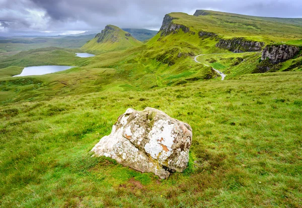 stock image Beautiful,dramatic Scottish mountainous scenery,pointed,jagged mountain peaks and sheer cliff faces, along the Quiraing hills walk,green grass and shrub covered in the mid summer,north eastern Skye.