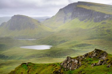 Quiraing yürüyüş döngüsü, güzel, çarpıcı, dramatik İskoç, Skye Adası dağ manzarası, pürüzlü kayalar ve tepeler, antik heyelan kalıntıları, dönemeç yollar, yazın ortasında sarp kayalıklar ve göller.