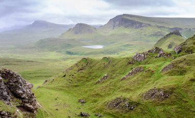 Quiraing yürüyüş döngüsü, güzel, çarpıcı, dramatik İskoç, Skye Adası dağ manzarası, pürüzlü kayalar ve tepeler, antik heyelan kalıntıları, dönemeç yollar, yazın ortasında sarp kayalıklar ve göller.