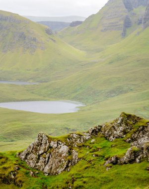 Quiraing yürüyüş döngüsü, güzel, çarpıcı, dramatik İskoç, Skye Adası dağ manzarası, pürüzlü kayalar ve tepeler, antik heyelan kalıntıları, dönemeç yollar, yazın ortasında sarp kayalıklar ve göller.