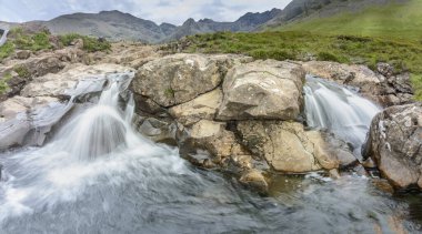 Kara Cuillin Dağları eteklerindeki uzun şelaleler ve kayalık dağ havuzları, popüler turistik yerler, muhteşem Skye manzarası, kayalarla ve yüzme alanlarıyla sarp bir yol..