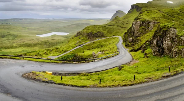 stock image Mountain road for traffic visiting the Quiraing walking trail,amongst beautiful dramatic scenery,winding down to the coast,on a rainy mid summer day.north east of Skye.