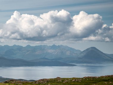 Sakin denizi aşıp Skye 'a, yazın gökyüzüne ve kabarık bulutlara, Applecross yarımadasındaki Wester Ross, İskoçya' daki kayalara, çarpıcı manzaralara, yaz mevsiminde.