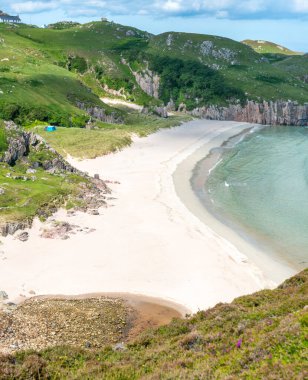 İskoç kamp yeri, büyüleyici kumlar, sakin Atlantik mavisi denizi, güneşli yaz sabahı, otlar Beinn Ceannabeinne dağının altında, güzel kum, dik otlak yamaçlar plaja erişim sağlar..