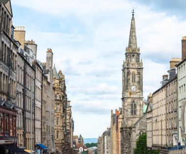 Edinburgh High Caddesi 'nden denize ve Firth of Forth nehrine doğru bakın. Eski şehir Gürcü binaları, yazın mavi gökyüzü, eski kilisenin saat kulesi.