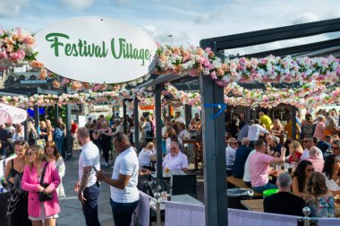 Edinburgh, İskoçya-30 Temmuz 2022: Birçok insan, Edinburgh Sınır Bilim Festivali sırasında, Princes Caddesi 'ndeki bu canlı yemek, içki ve müzik mekanında sıcak yaz havasının ve pembe çiçeklerin tadını çıkarıyor..