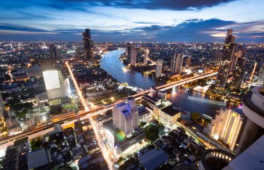 Gün batımından hemen sonra çekilen yüksek manzaralı çatı manzarası batıya bakıyor. Köprülerin ve uçurumların üzerindeki hafif tekne ve trafik yolları. Gökyüzünde parlama sonrası..