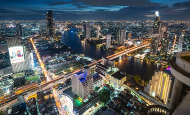 Gün batımından hemen sonra çekilen yüksek manzaralı çatı manzarası batıya bakıyor. Köprülerin ve uçurumların üzerindeki hafif tekne ve trafik yolları. Gökyüzünde parlama sonrası..
