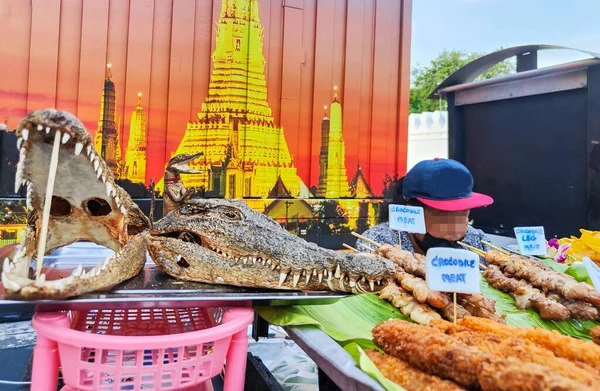 出售的鳄鱼肉 挂在竹竿上 放在银盘上晒干的头 用来为受欢迎的泰国肉做广告 在寺庙附近出售 — 图库照片