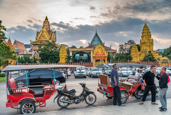2022年12月23日カンボジア プノンペン 太陽が沈む午後遅くにカンボジアの首都の主な観光地の前に駐車し 顧客を待っているときにバイクの人力車の運転手がチャット — ストック写真