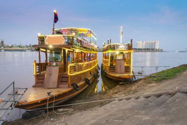 Renkli bir şekilde alacakaranlıkta, Phnom Penh 'in Riverside bölgesinde, turistler için gece kulübü olarak kullanılıyor, yemek ve dans, gezintiler, parlak ışıklar, Tonle Sap ve Mekong nehirleri arasında gidip gelirken.