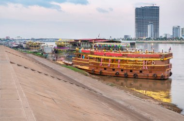 Renkli bir şekilde alacakaranlıkta, Phnom Penh 'in Riverside bölgesinde, turistler için gece kulübü olarak kullanılıyor, yemek ve dans, gezintiler, parlak ışıklar, Tonle Sap ve Mekong nehirleri arasında gidip gelirken.