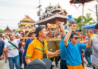 Pai, Mae Hong Son, Tayland-4 Nisan 2023: 7-14 yaşları arasında Budist rahipler olarak atanmak üzere olan çocuklar, kalabalığın kutlamaları sırasında erkeklerin omuzlarında sokaklarda taşınıyor..