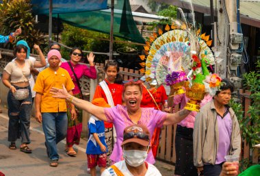 Pai, Mae Hong Son, Tayland-4 Nisan 2023: Geleneksel giysiler içinde, yedi ila on dört yaşları arasında Budist keşiş olan erkek çocuklarının papazlığını kutlamak için sokaklara dökülen kalabalık.