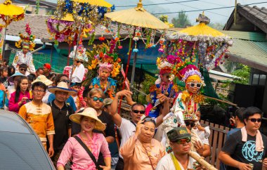 Pai, Mae Hong Son, Tayland-4 Nisan 2023: 7-14 yaşları arasında Budist rahipler olarak atanmak üzere olan çocuklar, kalabalığın kutlamaları sırasında erkeklerin omuzlarında sokaklarda taşınıyor..