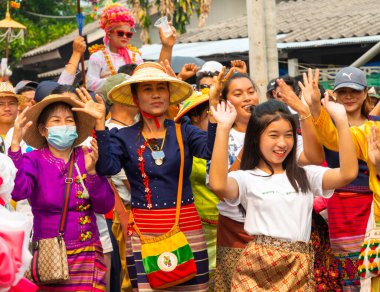 Pai, Mae Hong Son, Tayland-4 Nisan 2023: Geleneksel giysiler içinde, yedi ila on dört yaşları arasında Budist keşiş olan erkek çocuklarının papazlığını kutlamak için sokaklara dökülen kalabalık.