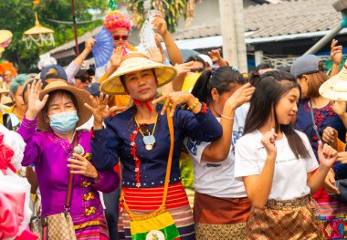 Pai, Mae Hong Son, Tayland-4 Nisan 2023: Geleneksel giysiler içinde, yedi ila on dört yaşları arasında Budist keşiş olan erkek çocuklarının papazlığını kutlamak için sokaklara dökülen kalabalık.