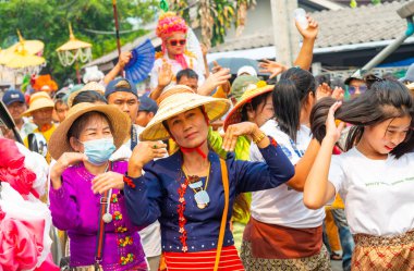 Pai, Mae Hong Son, Tayland-4 Nisan 2023: Geleneksel giysiler içinde, yedi ila on dört yaşları arasında Budist keşiş olan erkek çocuklarının papazlığını kutlamak için sokaklara dökülen kalabalık.