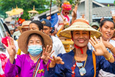 Pai, Mae Hong Son, Tayland-4 Nisan 2023: Geleneksel giysiler içinde, yedi ila on dört yaşları arasında Budist keşiş olan erkek çocuklarının papazlığını kutlamak için sokaklara dökülen kalabalık.