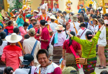 Pai, Mae Hong Son, Tayland-4 Nisan 2023: 7-14 yaşları arasında Budist rahipler olarak atanmak üzere olan çocuklar, kalabalığın kutlamaları sırasında erkeklerin omuzlarında sokaklarda taşınıyor..