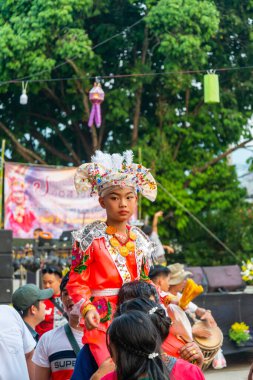 Pai, Mae Hong Son, Tayland-4 Nisan 2023: 7-14 yaşları arasında Budist rahipler olarak atanmak üzere olan çocuklar, kalabalığın kutlamaları sırasında erkeklerin omuzlarında sokaklarda taşınıyor..
