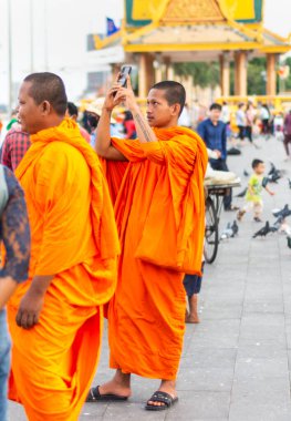 Phnom Penh, Kamboçya-4 Ocak 2023: Civardaki tapınaklardan gelen her yaştan keşişler, başkent nüfusunun geri kalanıyla kaynaşıp, akşam yemek ve dinlenmek için buraya gelirler..