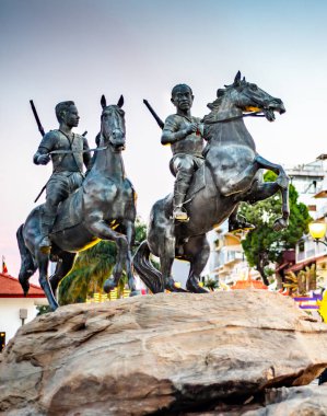 Phnom Penh, Kamboçya-4 Ocak 2023: Riverside yürüyüşü boyunca büyük bir kayanın üzerine monte edildi. İki kahraman, tarihi Khmer savaşçısının gün batımında at sırtında savaşa giderken çekilmiş bir tasviri..