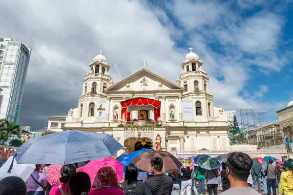 Manila, The Filippines, Jan 07 2023: İnsanlar sıcak güneşin altında, Quiapo Kilisesi 'nin dışında, Traslacin' den bir gün önce, ya da geçit yürüyüşü öncesinde, Kara Nazarene bayramını ya da İsa 'yı anmak için ibadet ediyorlar..