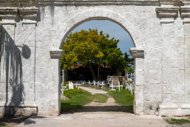 Beyazlatılmış taştan yapılmış büyük kemerli yapı, bir ağaca, birçok odalı mezarın ve bu büyük alanı dolduran yüzlerce mezarı işaret eden beyaz haçların ana alanına açılıyor..