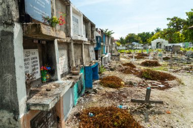 Atmosferik Filipin Katolik mezarlığı, Cebu Boğazı 'nın yanında, birçok odalı mezar, merhumların barındığı, yüzlerce haç, rastgele sıralanmış mezarlar, deniz duvarı ve sahil duvarı..