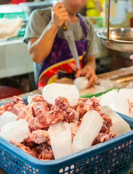 肉切断刃の鋭い尖った端を使用して 男は午後の食品市場で販売される生の豚肉と混合するために氷を分解します — ストック写真