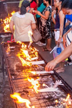 Dumaguete, Negros Adası, Filipinler-Şubat 01: 2023: Kendini adamış Katolikler, Hıristiyan ikonlarına şükranlarını sunmak için her gün kutsal bölgeyi ziyaret edin..