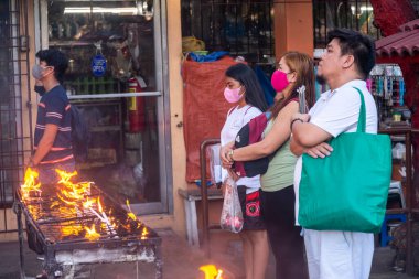 Dumaguete, Negros Adası, Filipinler-Şubat 01: 2023: Kendini adamış Katolikler, Hıristiyan ikonlarına şükranlarını sunmak için her gün kutsal bölgeyi ziyaret edin..