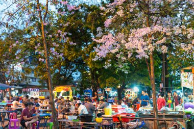 Chiang Mai, Tayland-20 Mart 2023: Gün batımında, eski şehir duvarları ve çevre eski şehir hendekleri arasında müşteriler ve şefler lezzetli yerel yemekleri yemek ve yemek için gelirler..