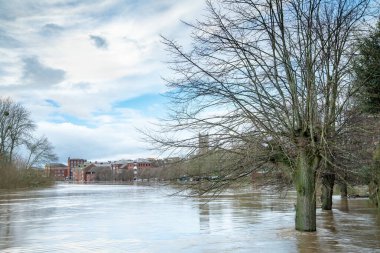 Significant flooding from rain water pouring into the Severn river,covering fields and pathways, from sourounding hills and countryside after prolonged winter,New Year precipitation,at sunset.