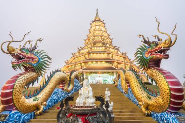 Büyük aydınlatılmış pagoda, alacakaranlıkta, mimari Çin Guan Yin heykelinin, ejderha merdivenlerinin, beyaz mermer Buda ve Tayland tarzı mimarinin karışımı. Güzel modern Tayland tapınak yapıları..