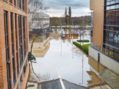 Worcester,Worcestershire,UK-January 05 2024:Flood waters,caused by heavy rains,and high river levels,enter public areas,heading along roads into the city,causing disruption and flooding properties. clipart