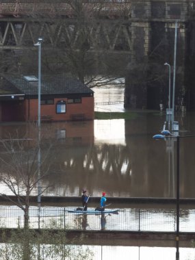 Worcester, Worcestershire, İngiltere-05 Ocak 2024: İnsanlar, aşırı hava koşullarından sonra Severn Nehri 'nin taşan kıyılarından yağışlı yağmurlar, fırtınalar ve büyük sel baskınları için kürek tahtası kullanıyorlar..