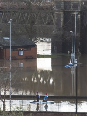 Worcester, Worcestershire, İngiltere-05 Ocak 2024: İnsanlar, aşırı hava koşullarından sonra Severn Nehri 'nin taşan kıyılarından yağışlı yağmurlar, fırtınalar ve büyük sel baskınları için kürek tahtası kullanıyorlar..