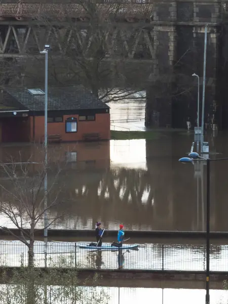 Worcester, Worcestershire, İngiltere-05 Ocak 2024: İnsanlar, aşırı hava koşullarından sonra Severn Nehri 'nin taşan kıyılarından yağışlı yağmurlar, fırtınalar ve büyük sel baskınları için kürek tahtası kullanıyorlar..