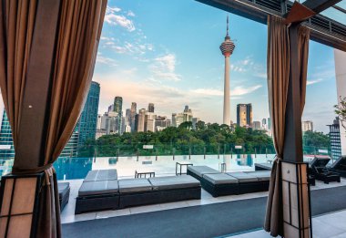 Kuala Lumpur, Malezya-20 Nisan 2023: Otel yüzme havuzu ve bar alanı, modern şehir silueti ve KL Kulesi boyunca manzaralar sunuyor.