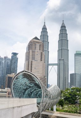 The exquisite modern covered bridge,opened in 2020,leading,from the Muslim cemetery, across the Klang River and busy highway to the old district of Kampung Baru,with modern skyscrapers beyond. clipart
